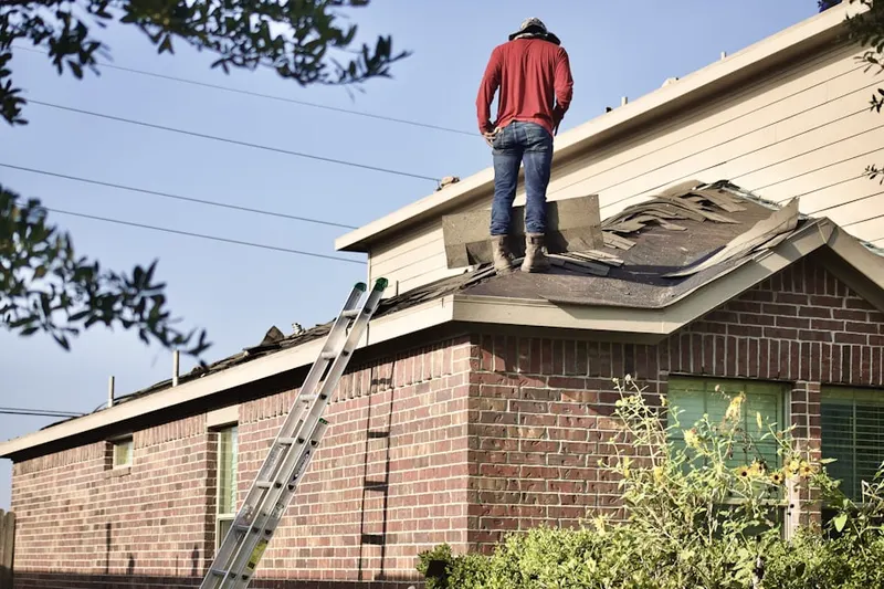 Professional roofer working on a residential roof in New Hampshire Gardens